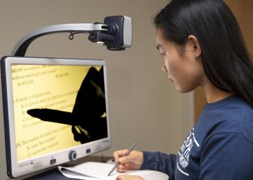 Student using assistive technology to review information on a computer screen.