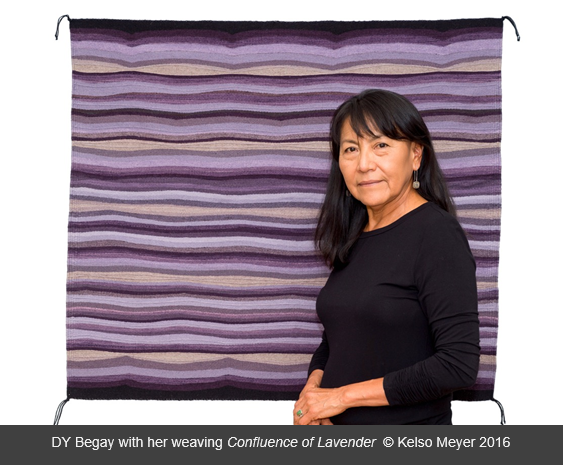 Artist DY Begay in front of weaving piece titled Confluence of Lavender